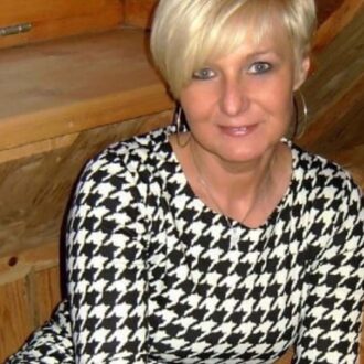 Femme mûre élégante à Lyon assise en intérieur, cherche rencontre douce et authentique