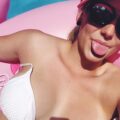 Mélanie allongée en bikini, tirant la langue sur une bouée rose à Marseille, cherche plan baise fun avec homme qui ose le jee